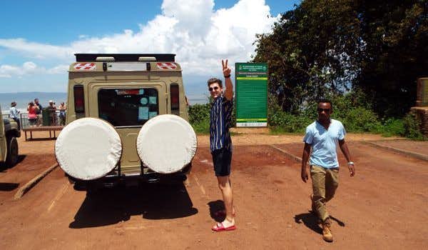 viajero y guia junto al jeep privado de la excursion de un dia al ngorongoro