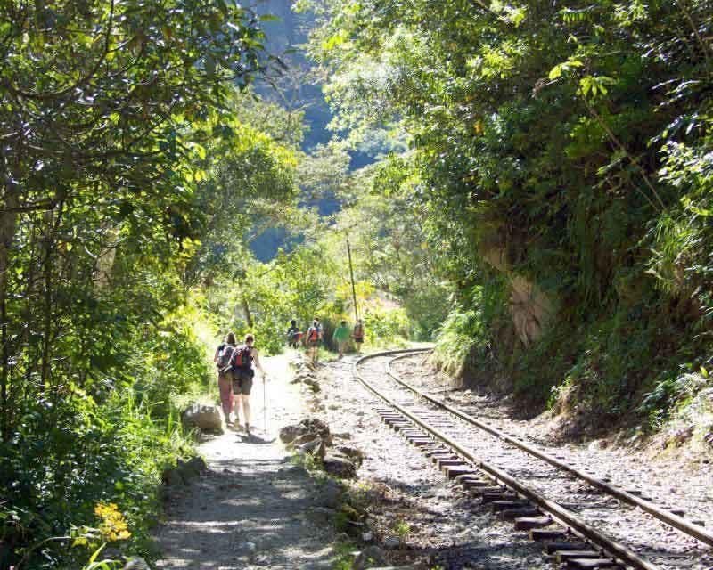 group of hikers walking along the hydroelectric railroad tracks