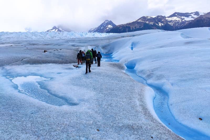 Gruppo che cammina sul ghiaccio del Perito Moreno con il fiume