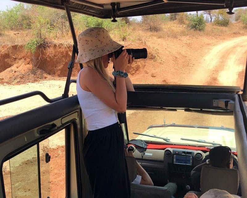 Viajante tirando fotos no jipe da excursão
