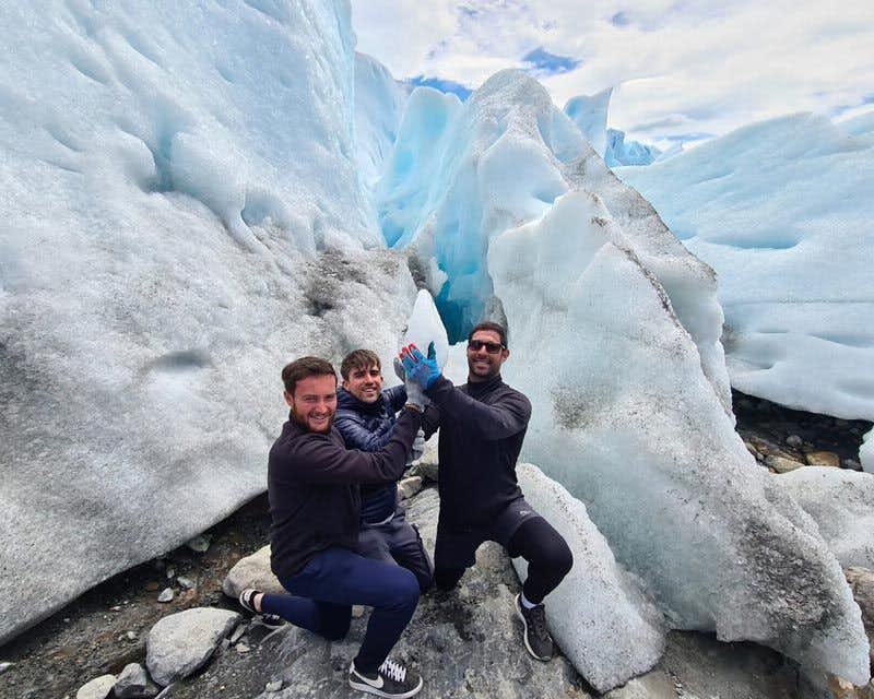três meninos levantando um pedaço de gelo