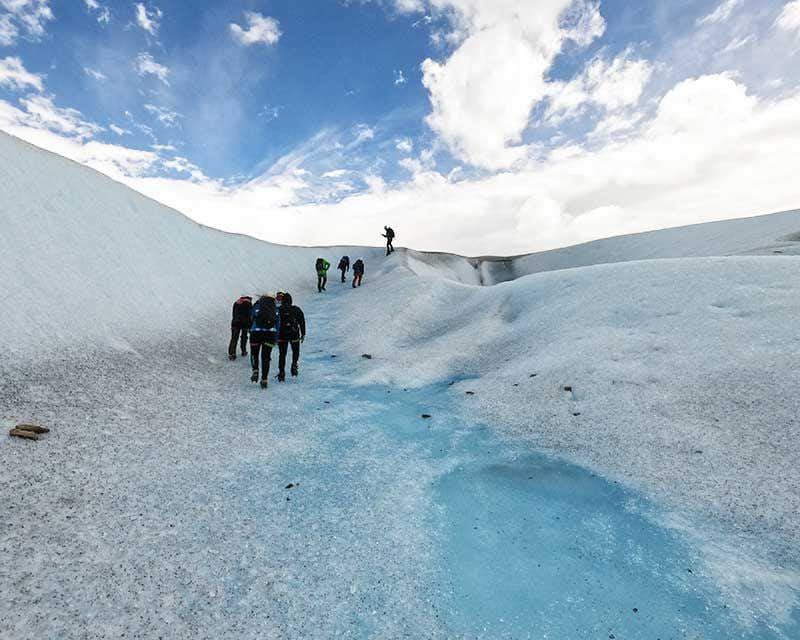 pessoas fazendo trilha no gelo grande na geleira perito moreno