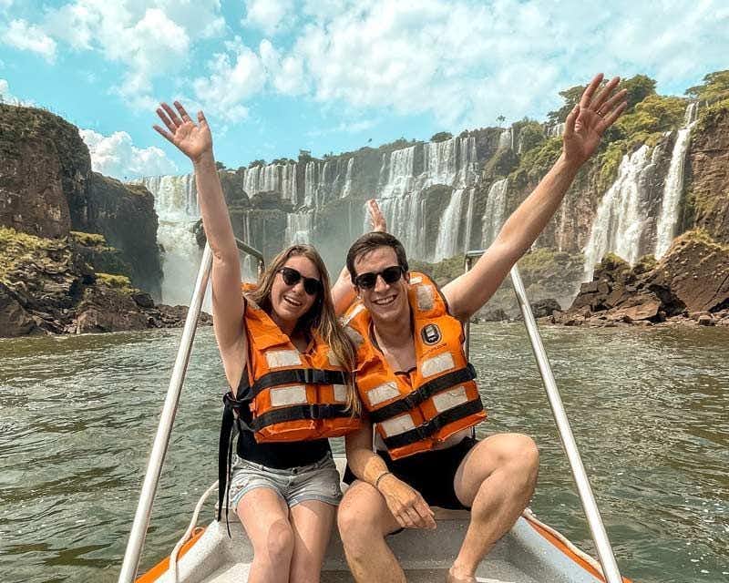 casal em uma lancha com as Cataratas do Iguaçu ao fundo