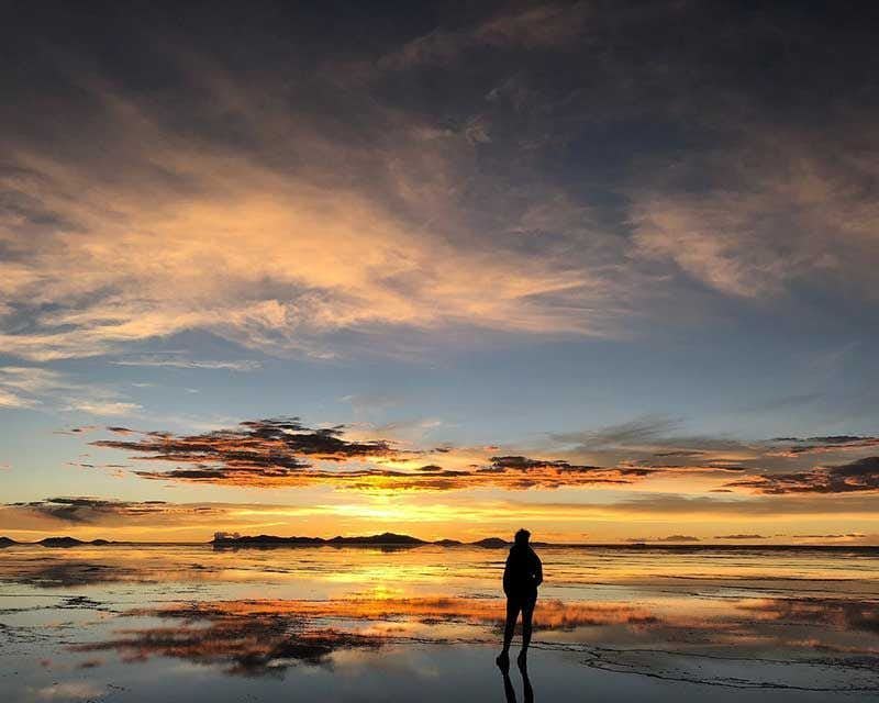 garota em frente ao nascer do sol em uyuni