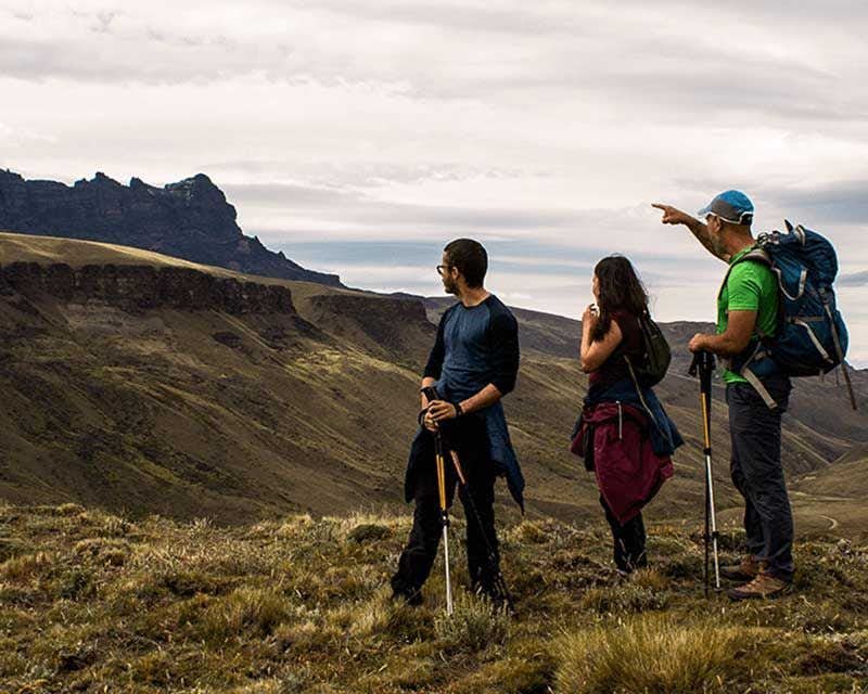 três pessoas em uma trilha guiada na sierra baguales