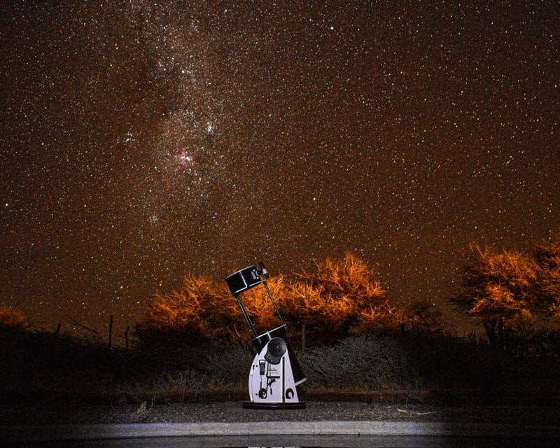telescópio à noite com o céu estrelado