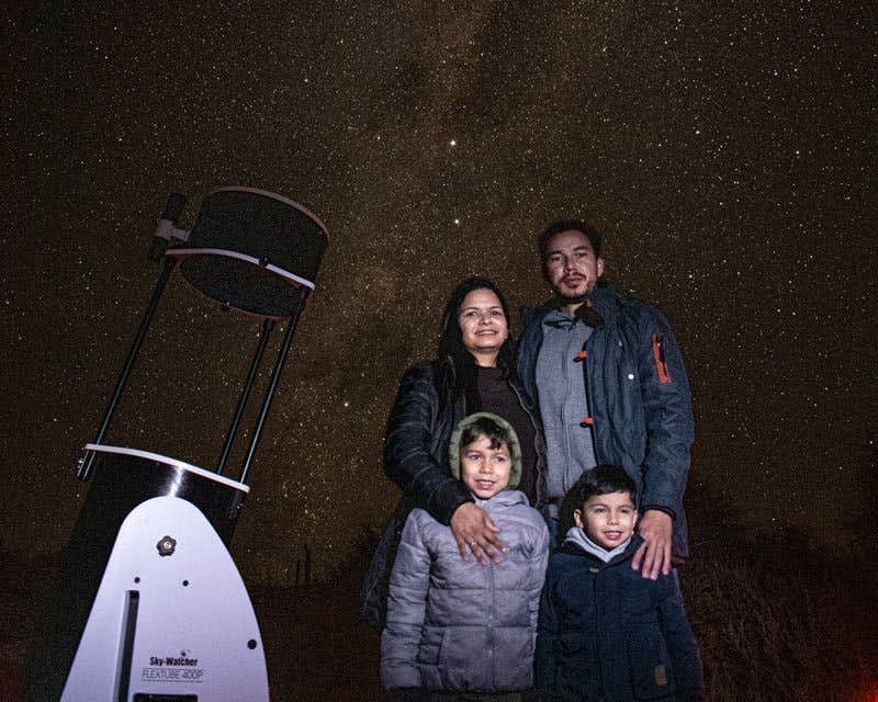 Família posando em frente ao céu estrelado