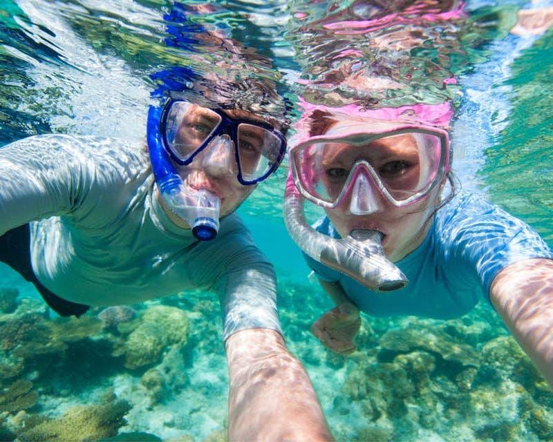 selfie de um casal mergulhando com tubo de respiração