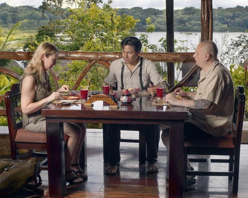 três pessoas jantando no terraço do chalé