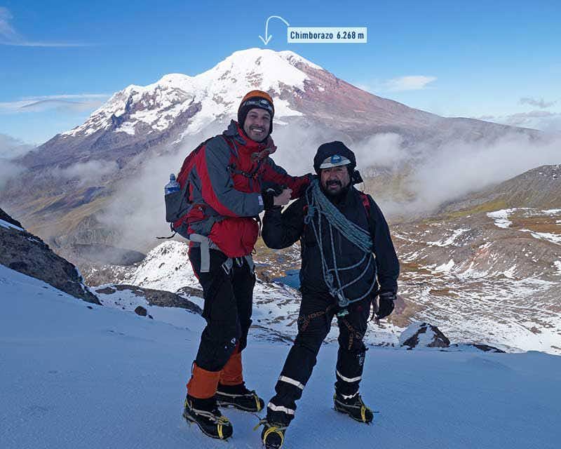 Alpinista e guia felizes após chegarem ao cume de Carihuairazo