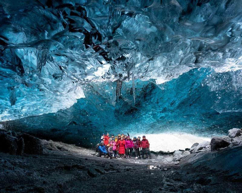 Grupo dentro da caverna de gelo azul safira na Islândia