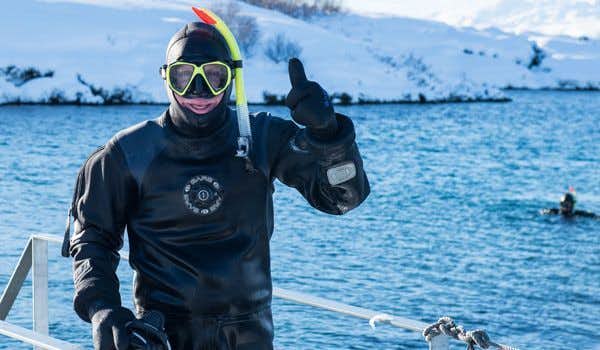 Viajante posa após mergulhar com snorkel nas placas tectônicas da Islândia
