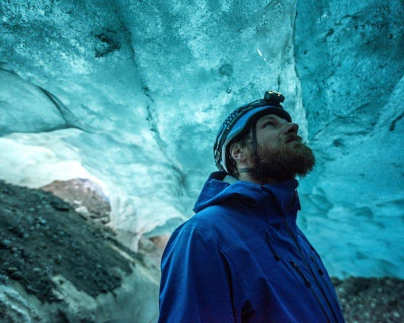 Viajante dentro da caverna de gelo azul
