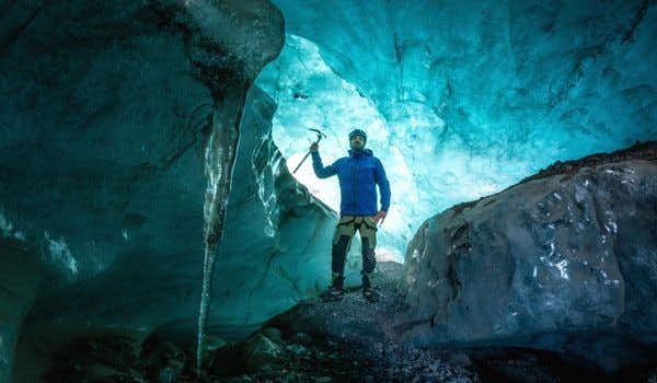 Viajante dentro de uma caverna de gelo azul