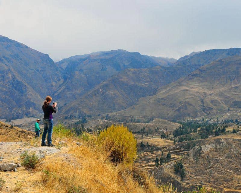 Viajante tirando fotos da paisagem do Colca Canyon