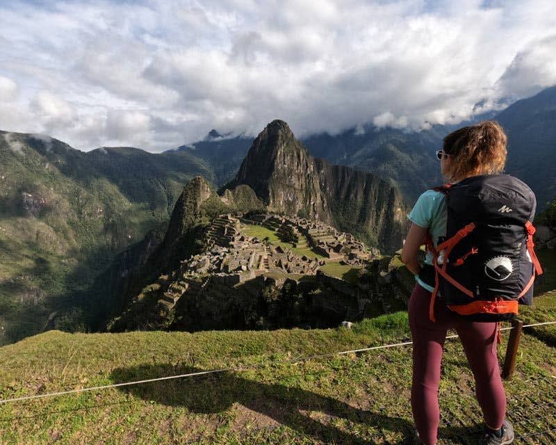 garota mochileira de Howlanders observando Machu Picchu