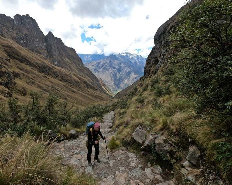 garota subindo escadas na trilha inca com bastões de trekking