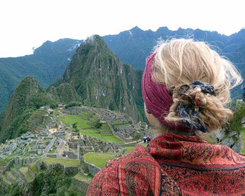 Menina olhando para Machu Picchu com a montanha Huayna Picchu ao fundo na trilha premium de Salkantay
