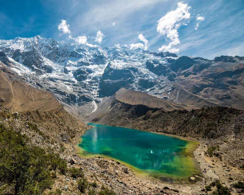Lagoa verde com geleira ao fundo na trilha Salkantay Premium para Machu Picchu