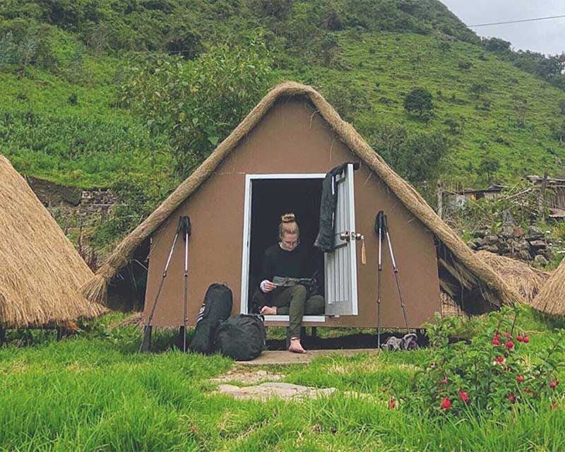 Garota dentro de uma das cabanas andinas no acampamento Salkantay Trek