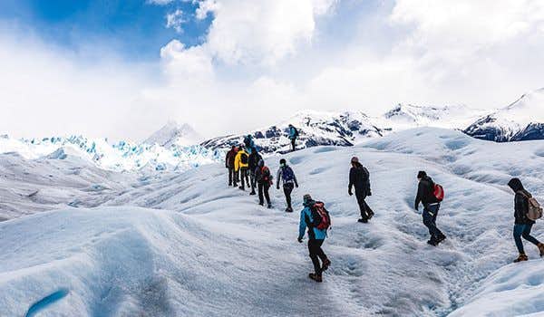 Menschen, die auf dem Gletscher neben einem See im Perito Moreno Gletscher Minitrekking gehen