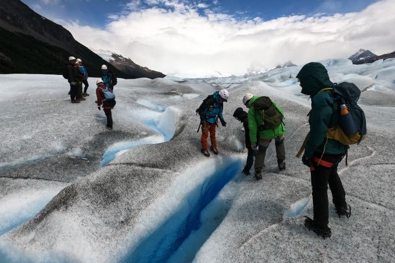 Gruppe lehnt sich aus der Gletscherspalte des Perito Moreno