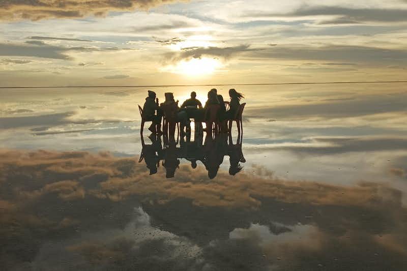 sitzende gruppe auf der salzfläche von uyuni