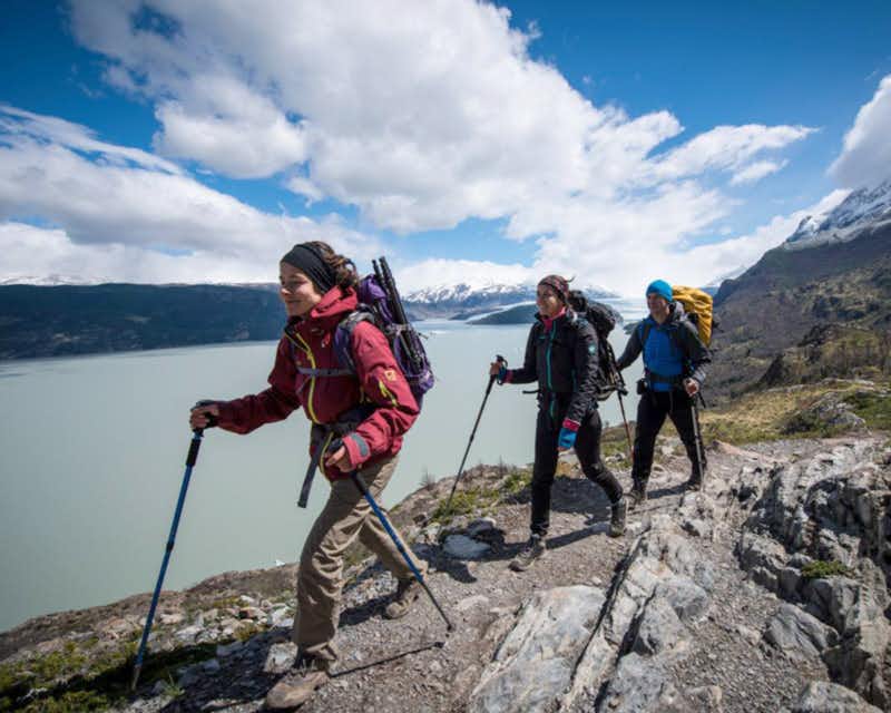 Wanderer, die mit dem grauen See im Hintergrund bei Torres del Paine wandern