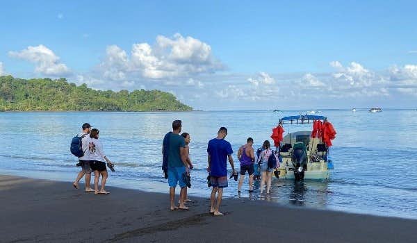 Reisende steigen in das Boot zur Insel Cano
