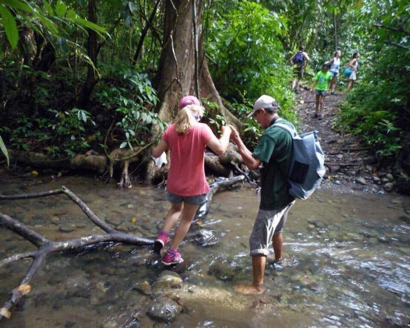 Reisende beim Überqueren eines Baches in Costa Rica
