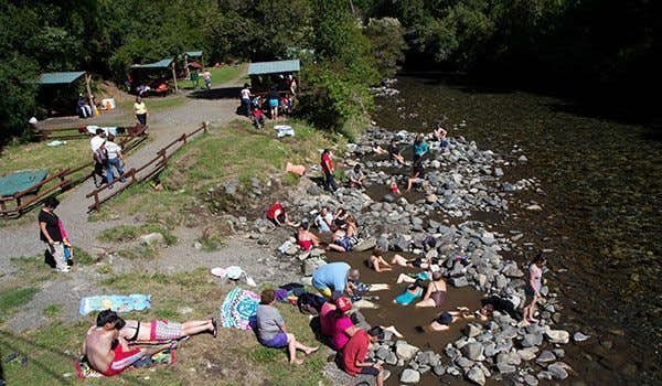 Touristen genießen die heißen Quellen in Aguas Calientes