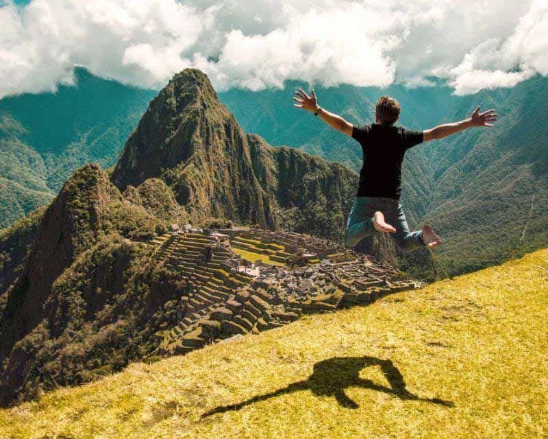 Junge springt auf der Zitadelle von Machu Picchu