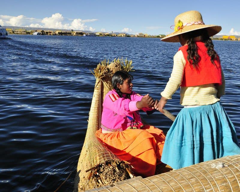 zwei Mädchen auf einem Boot titicacasee uros inseln