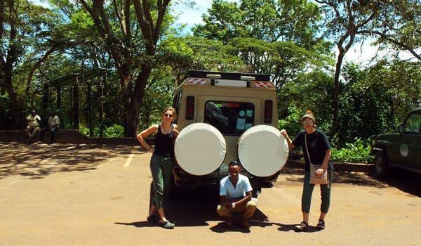 travelers and guide with safari jeep