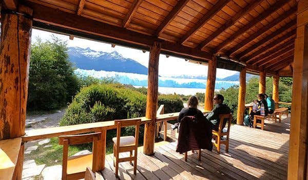 people resting on the terrace in front of the perito moreno glacier