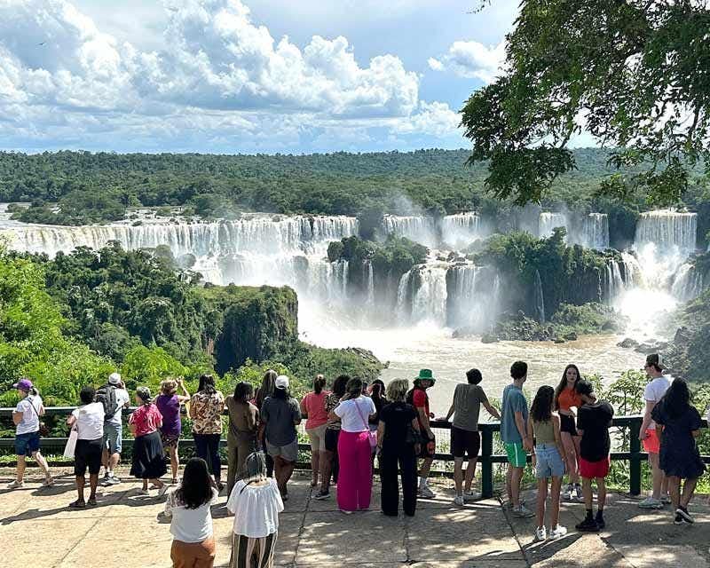 people watching the panoramic view of the brazil side waterfall