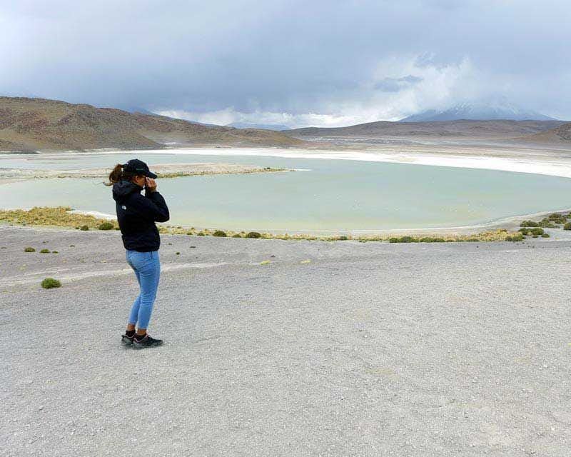 Tourist at the Altiplanic Lagoon with the cloudy sky in the background