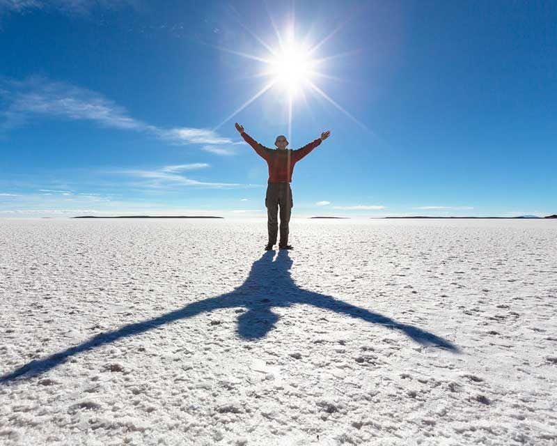 funny photo boy playing with the sun in the uyuni salt flats