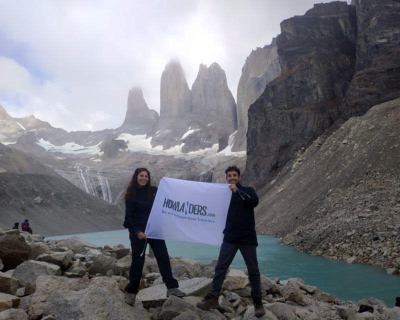 couple with howlanders flag at torres del paine base viewpoint 