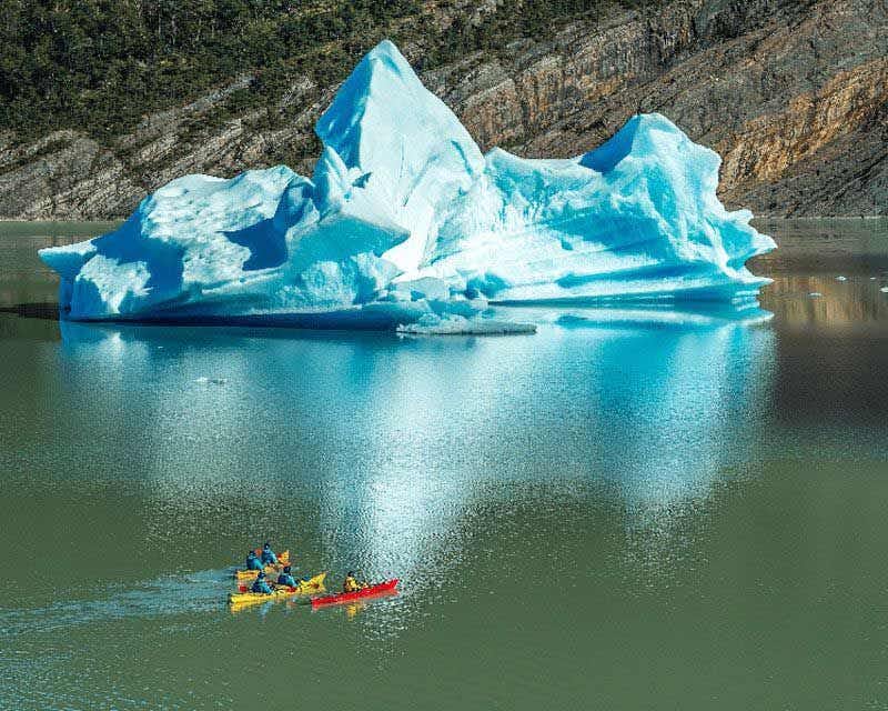 three kayaks navigating through the grey lake