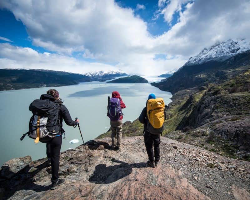 Hikers observing lake and glacier Grey