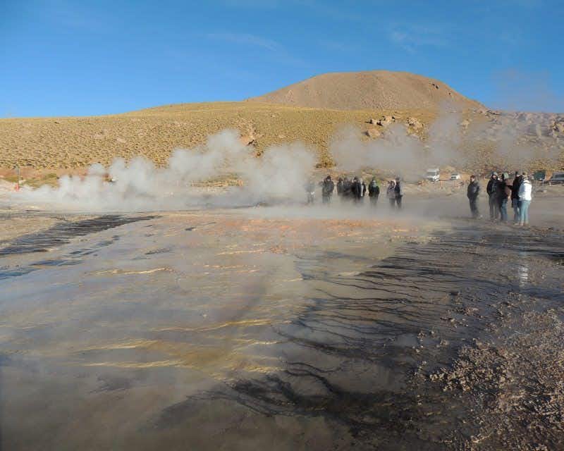 group of travelers next to the geysers