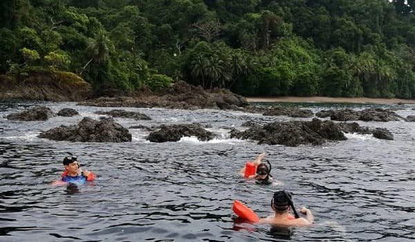 travelers snorkeling near cano island