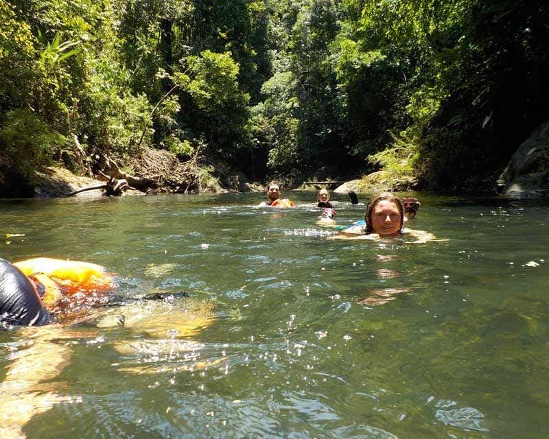 travelers floating in rio Claro
