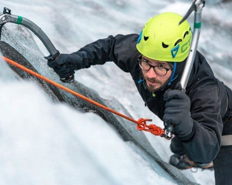 man ice climbing with axe scaftafell