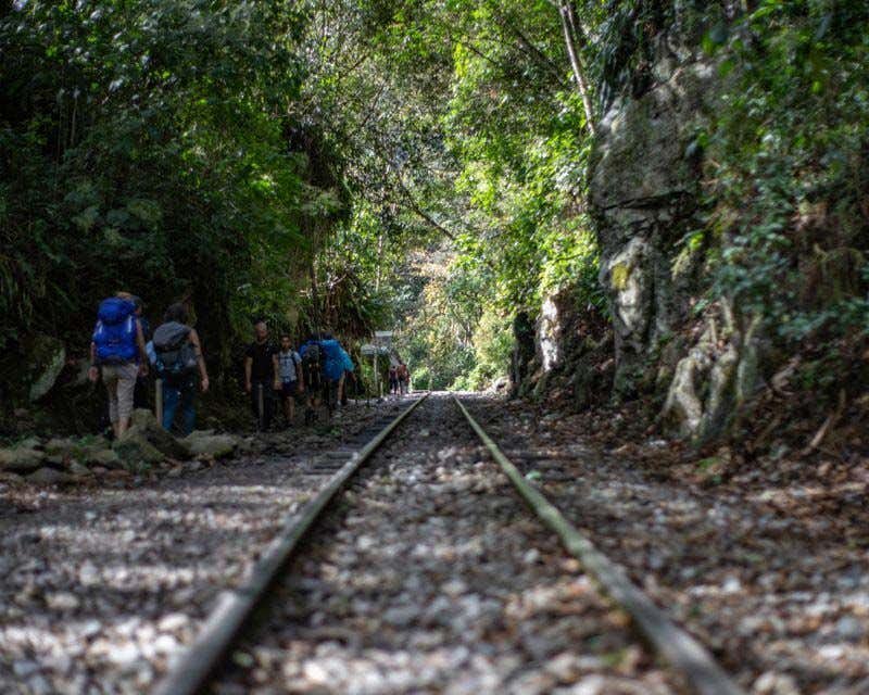 people walking along the train tracks on the inca jungle trek