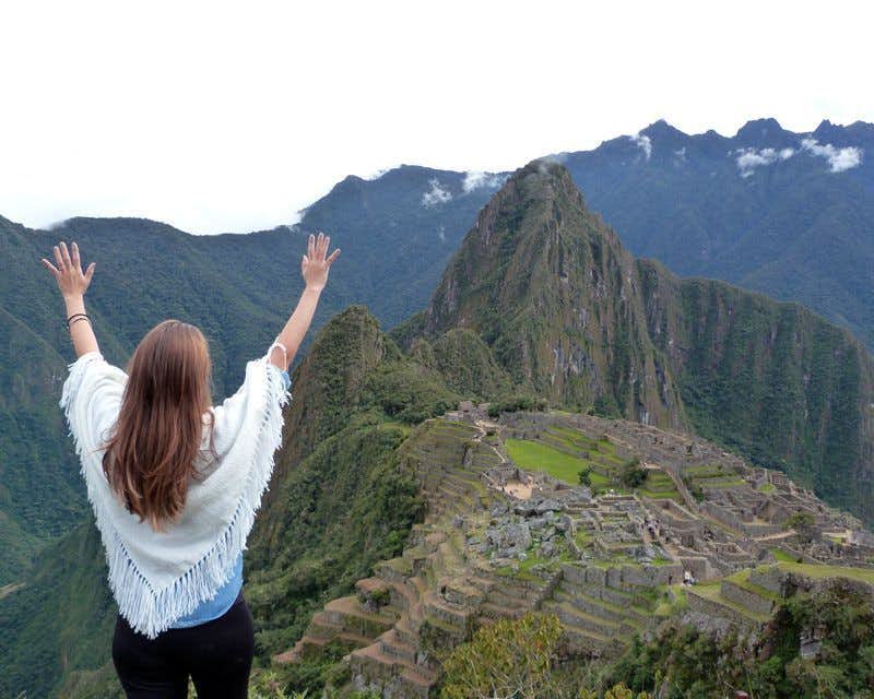 girl on her back in huayna picchu with views of machu picchu