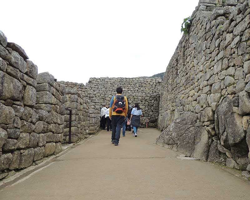 boy howlanders walking through the ruins of Machu Picchu