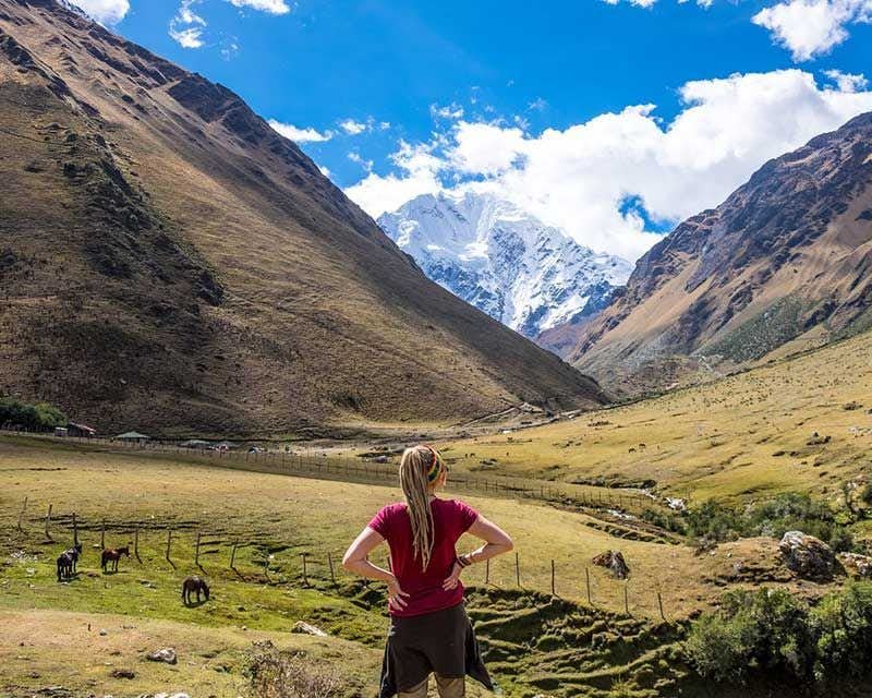 girl on her back with snow-capped salkantay mountain in the background