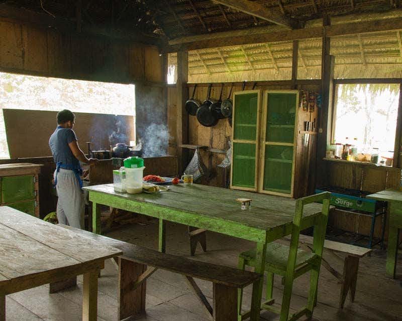 Cook working in the kitchen of the private lodge for Iquitos jungle tour
